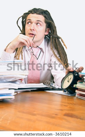 Young man holds glasses and keeps his hand on alarm clock