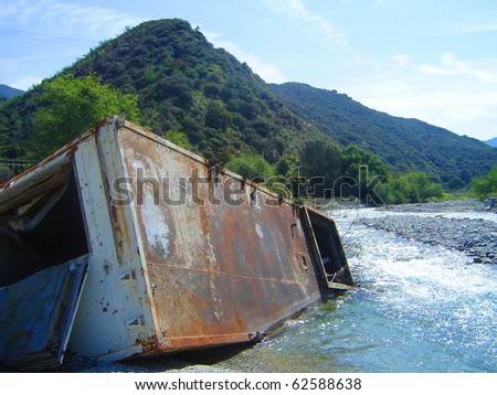 This is a shipping container in the East Fork River in the San Gabriel Mountains of California.