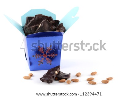 Dark chocolate almond bark in blue snowflake box on white background
