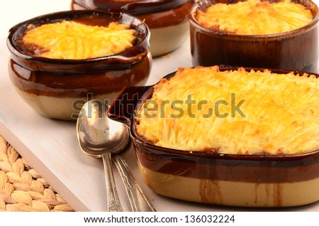 Hot from the oven homemade shepherd\'s pie with cheesy mashed potatoes in small casserole dishes