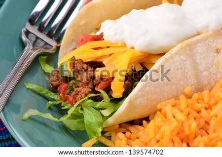 Soft tortilla with spicy ground beef, salsa , sour cream and cheese with Mexican rice