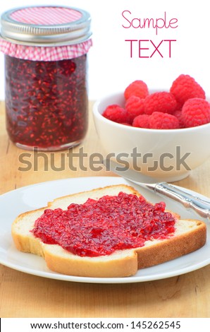 Fresh home made raspberry jam with slice of bread and jam and fresh raspberries, vertical composition