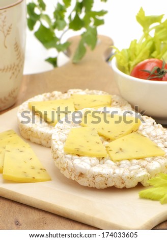 Healthy snack of multigrain rice cakes with spiced gouda cheese in vertical format