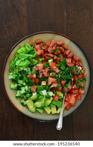 Fresh chopped greens, cucumber, tomato, avocado and scallions with red kidney beans and flat leaf parsley and a lemon garlic dressing make a lovely summer salad
