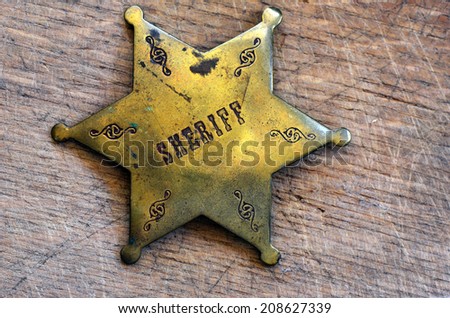Sheriff badge on rustic wooden background