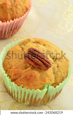Gluten free banana pecan muffins on sparkly gold napkin in vertical format