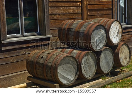 Old wooden barrels stacked outside wood frame house at historic Fort Langley, British Columbia