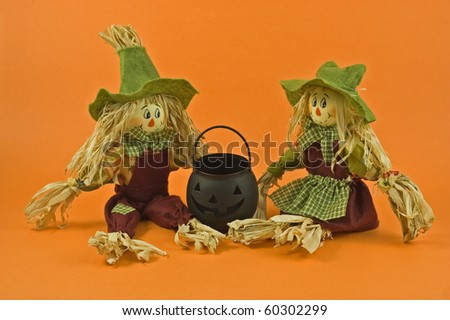 Halloween or Thanksgiving theme straw dolls on orange background