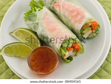 Prawn summer roll sushi with sweet chili sauce and lime on white plate