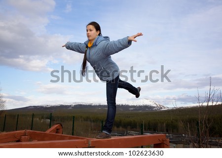 Girl Doing Gymnastic Element Of Balance On One Leg On The Balance Beam