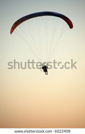 silhouette of a man in a motorized hang glider