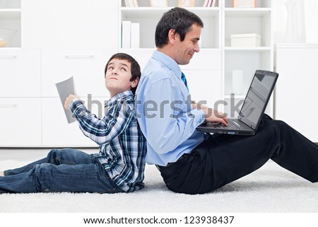 Sad boy with his busy father at home