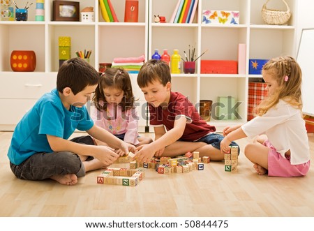 Children playing with blocks on the floor - focus on the boy\'s face