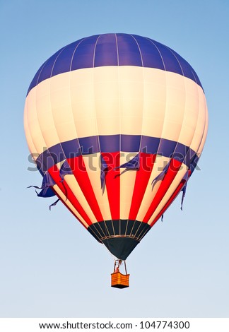 A red, white and blue balloon rises in the sky above Colorado\'s Balloon Classic