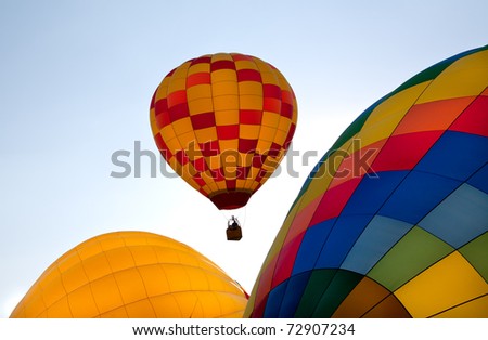 Colorful balloon ascending over inflating canopies at the Colorado Balloon Classic in Colorado Springs