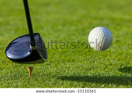 Golf ball hit off the tee with driver on golf course