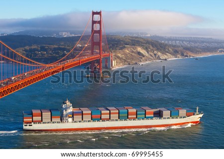 Fully laden container cargo ship leaving San Francisco bay under the Golden gate bridge in the late afternoon