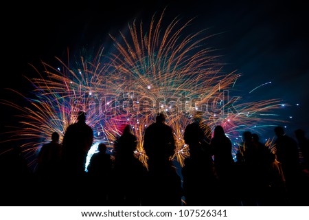Big fireworks with silhouettes of people watching it