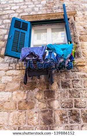 Drying laundry by hanging it on the rope from the window on the narrow street in Dubrovnik, Croatia