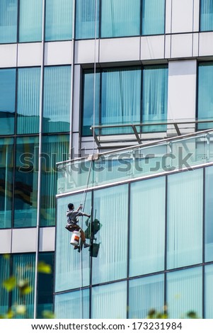 VANCOUVER, CANADA - MAY 16, 2007: Unidentified man washing windows on a glass skyscraper in Vancouver downtown.