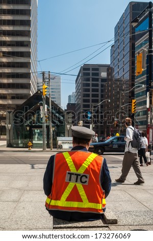 TORONTO, CANADA - MAY 10, 2007: Officer of Toronto Transit Commission observing traffic at University Ave. and King St. West. TTC is public transport agency that operates bus and streetcar services.