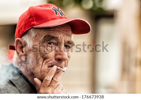 Zagreb, Croatia - May 24, 2009: Old Man Smoking Cigarette In Zagreb Center Square. People Are Allowed To Smoke Freely In Public Areas And Some Of The Restaurants In Croatia Without Violating Laws.
