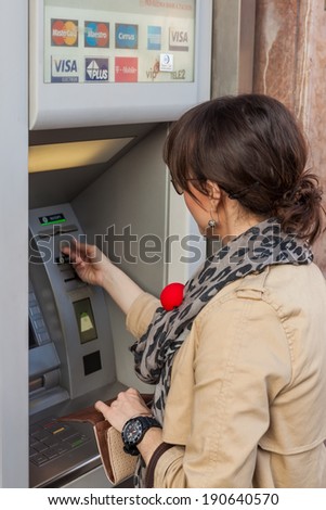 ZAGREB, CROATIA - JUNE 2, 2012: Unidentified girl withdrawing money from an ATM machine in city center. More than 4,000 ATM machines has been installed across Croatia since 1990.
