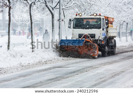 ZAGREB, CROATIA - DECEMBER 28, 2014: Snow plough cleaning the streets of Zagreb which are covered in snow and mud during heavy snowfall, first snowstorm of 2014.