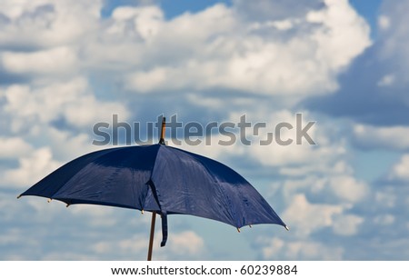 Blue umbrella against a cloudy sky