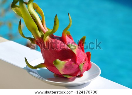 Pitaya - dragon fruit. Dragon Fruit on a plate in front of the pool.