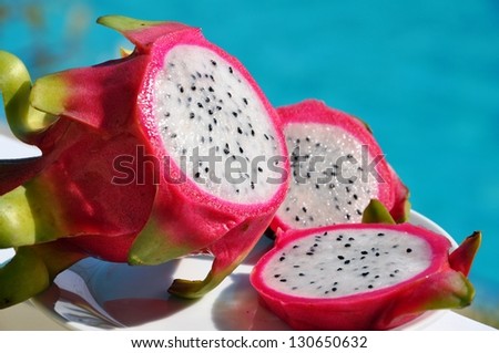 Pitaya - dragon fruit. Dragon Fruit on a plate in front of the pool.