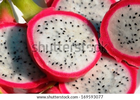 Pitaya - dragon fruit. Dragon Fruit cut into pieces on a white plate.