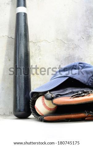 Baseball bat wit a cap and a glove with a ball in it