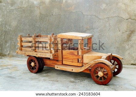 Old wood toy truck with a gray concrete grungy  background