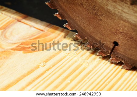 Macro shot of a table saw blade over a pine wood board
