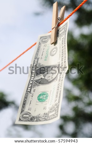 Dollar bill hanging from a cloth line depicting money laundry