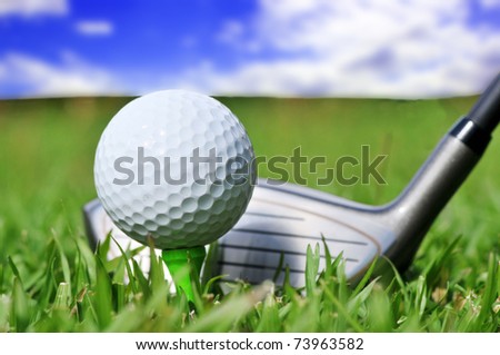 Macro shot of a golf club and ball with a beautiful blue sky in the background