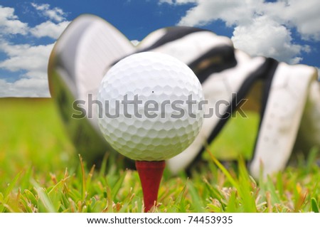 Golf  ball  driver and glove against a bright blue sky in the background