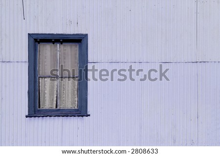 Window in a zinc metal wall, a typical train station construction. Negative space for copy. Mulberry tones.