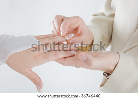 Groom hand putting a wedding ring on the bride finger