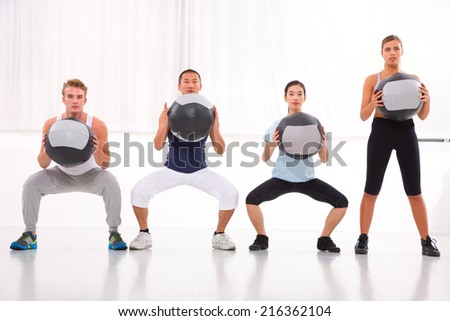 Diverse group of people exercising with pilates in gym