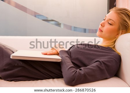 Young woman with laptop sleeping couch