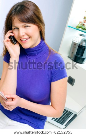 portrait of a young caucasian woman with mobile holding health card and booking medical exam