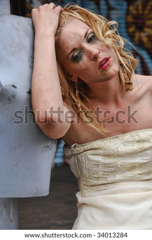 Sad lady in front of a wall of graffiti