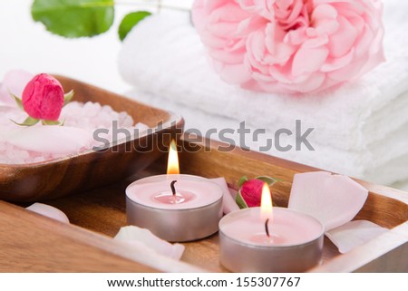 Pink candles and bath salt in wooden container - spa set in white and rose