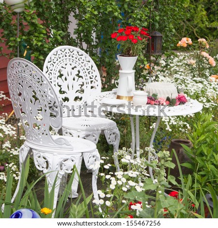 Garden furniture set with flowers growing in garden