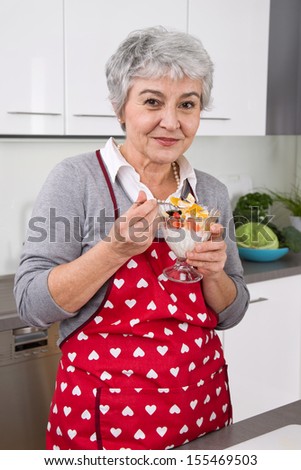 Senior woman cook and eat in kitchen