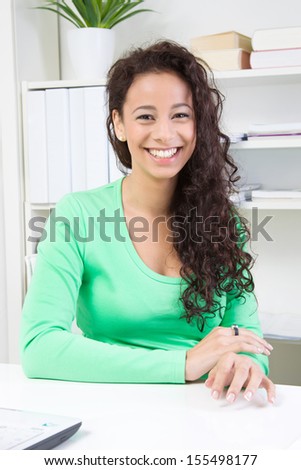 Happy young woman sitting in office