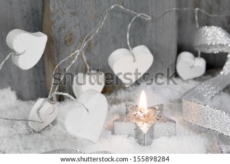 Winter decoration with silver star-shaped candle *** Local Caption *** Chrismas ornaments on window sill