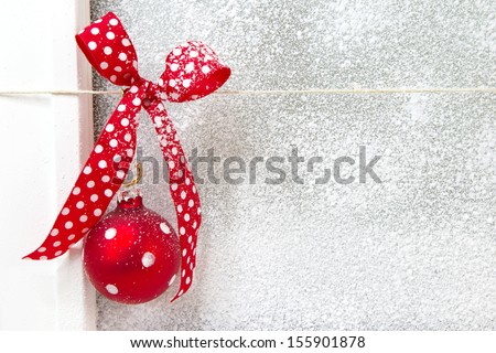 Close up of window decoration with red dotted ribbon and Christmas ball - polka dots - country style background for a greeting card